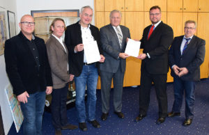 Landrat Wolfgang Spelthahn überreichte Bauherr Jens Emrich (2.v.r.) einen Förderbescheid des Landes NRW für den Quartierbau an der Schweizer Straße in Jülich. Einen weiteren Bescheid händigte er den Architekten Uwe Amend und Manfred Ott (2.u.3.v.l.) aus. Zudem im Bild: Alois Prinz (l.) und Hans-Jürgen Görgens (r.) vom Amt für Recht, Bauordnung und Wohnungswesen des Kreises Düren. Foto: Josef Kreutzer