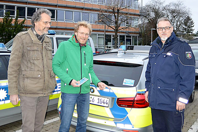 Der erste Aufkleber ist befestigt: Rob Maris und Jens Veith starteten mit Polizeihauptkommissar Guido Machunske die Aktion 