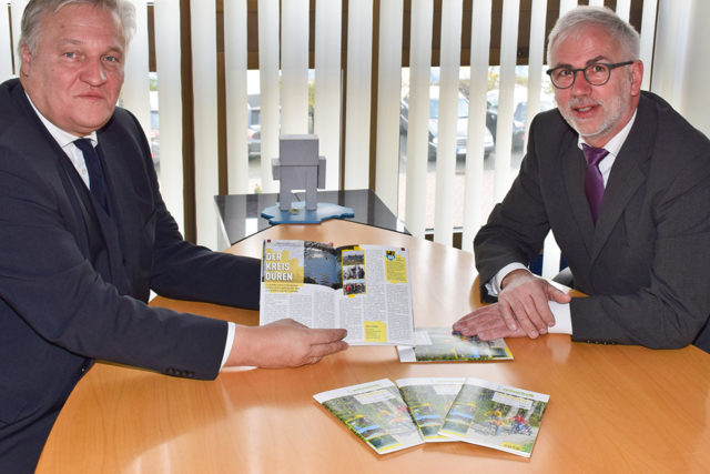 Landrat Wolfgang Spelthahn (l.) ist überzeugt, dass auch die neunte Auflage des Hefts von Dr. Norbert Dreßen wieder viele Menschen zu Ausflügen in der Region animiert. Foto: Kreis Düren