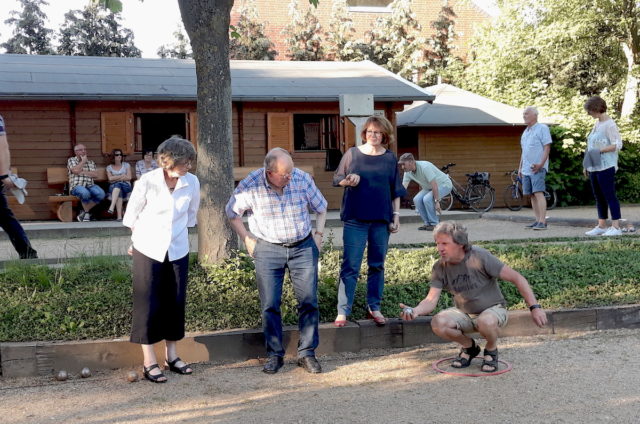 Karin Zoubek, Ortsvorsteher Peter Schmitz und Ruth Tavernier-Schwab (von links) lassen sich von Karl Sobotta in das Boulespiel einführen. Foto: Stadt Jülich/ B. Lenzen