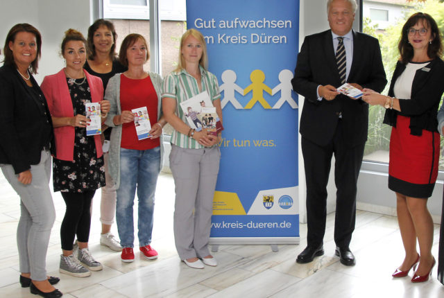 ehrenamtl. Lotsinnen Kopie Landrat Wolfgang Spelthahn nahm von der Leiterin des Amtes für Demografie, Kinder, Jugend, Familie und Senioren, Elke Ricken-Melchert (3. v. r), im Beisein von Lotsinnen und Kolleginnen eine Informationsbroschüre zur Unterstützung und Begleitung von Familien im Kreis Düren entgegen. Foto: Kreis Düren