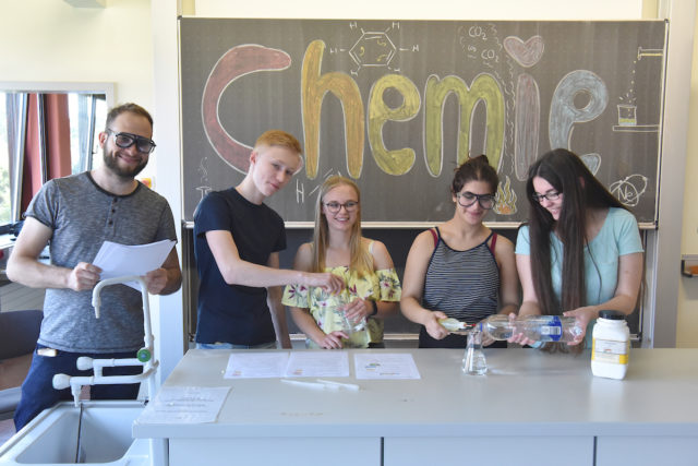 Oberstufenschülerinnen und Schüler mit Henry Bohnen an der Forschungsstation „Chemie“. Foto: Dirk Neumann