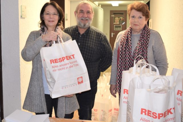 Rosemarie Willms (re.) verteilt die Tüten mit den die Lebensmittelspenden im Keller der Geschäftsstelle. Mit im Bild Sozialarbeiterin Brigitte Schall-Wagner und Fachbereichsleiter Rudolf Stellmach. Foto: Lehwald/Caritas.