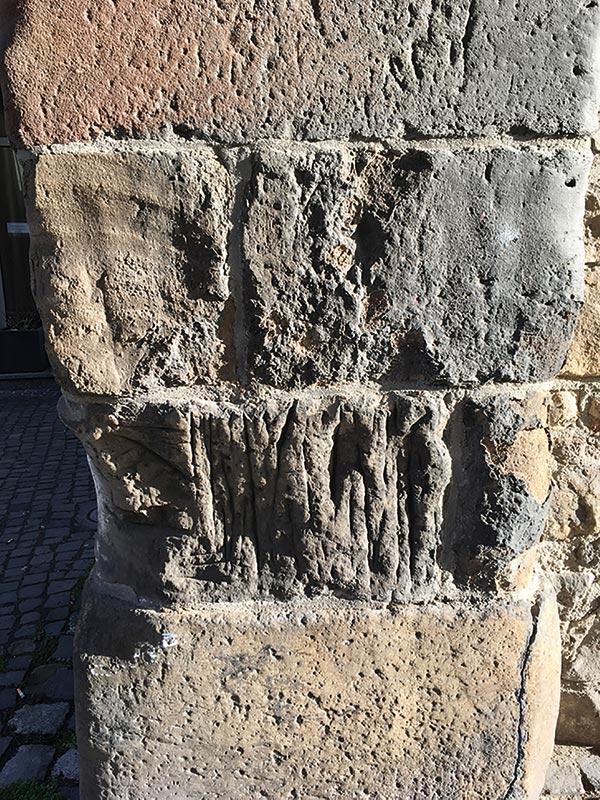 Solche Wetzstellen finden sich auch am Hexenturm. Eine Stadtmauer war Abbild des „Himmlischen Jerusalems“ und Sandabrieb von deren „heiligen Steinen“ spielte eine große Rolle in der Volksmedizin.