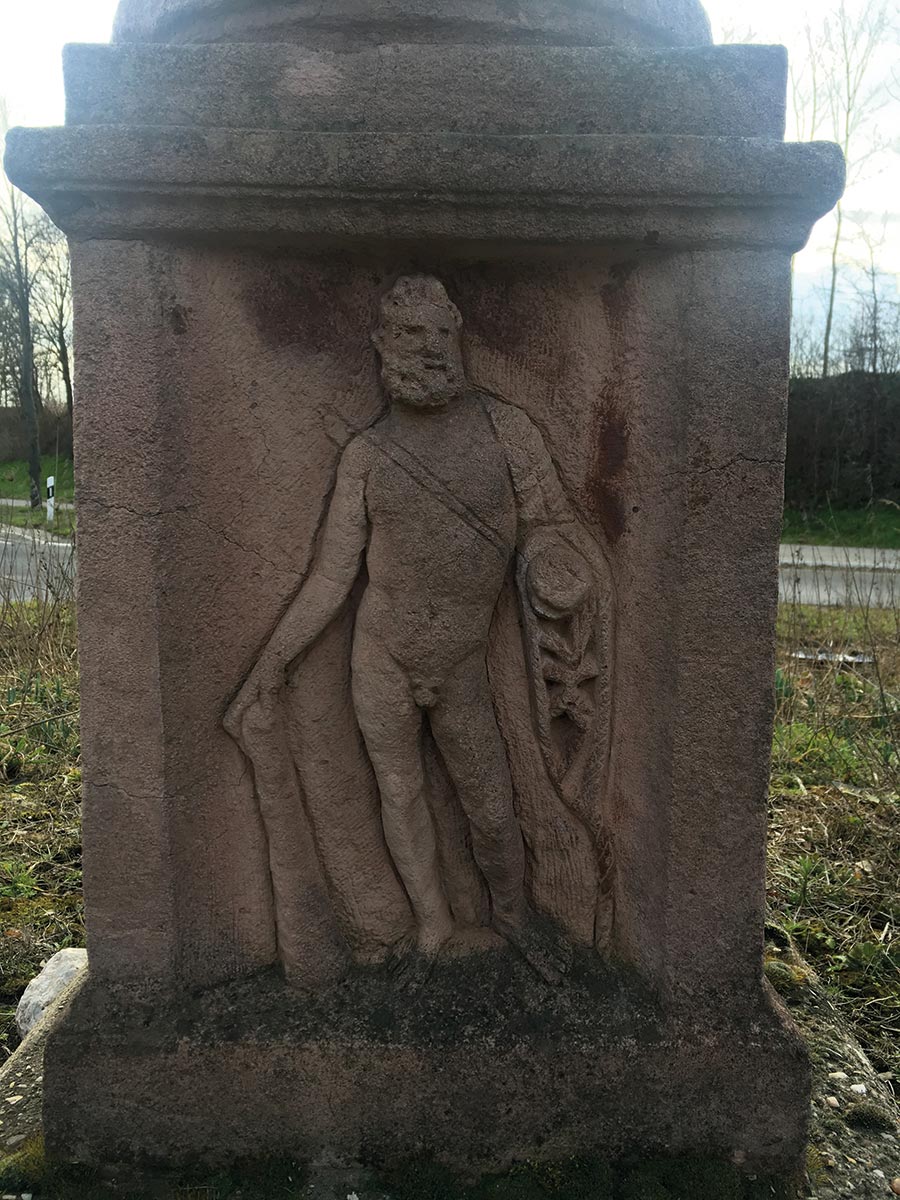 Im Kreisverkehr vor der Sophienhöhe in Stetternich steht der Abguss einer römischen Jupitersäule. Auch dort ist auf dem Sockel Herkules dargestellt. So kann man sich auch den Kopf des neuen Jülicher Steins vorstellen. Und in der linken Hand sind die goldenen Äpfel der Hesperiden zu ergänzen.